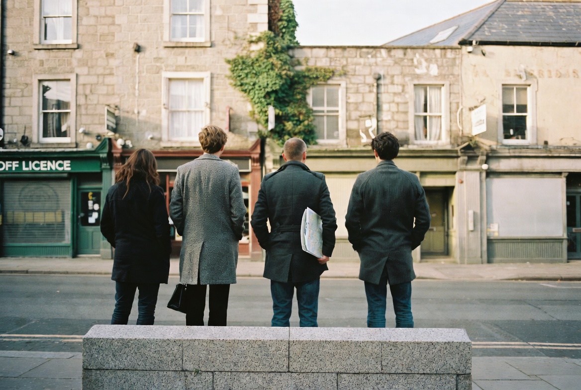 Two walkers and a guide pausing on a granite kerb in central Dublin.