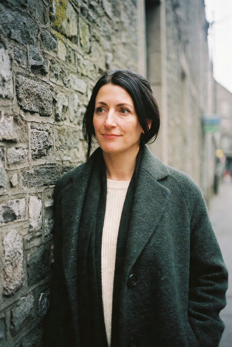 Síle Donnelly, lead guide, photographed beside a stone wall on Thomas Street, Dublin.